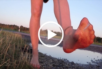 Nylonjunge: Helle Feinstrumpfhose und Strandschuhe in der Pfütze