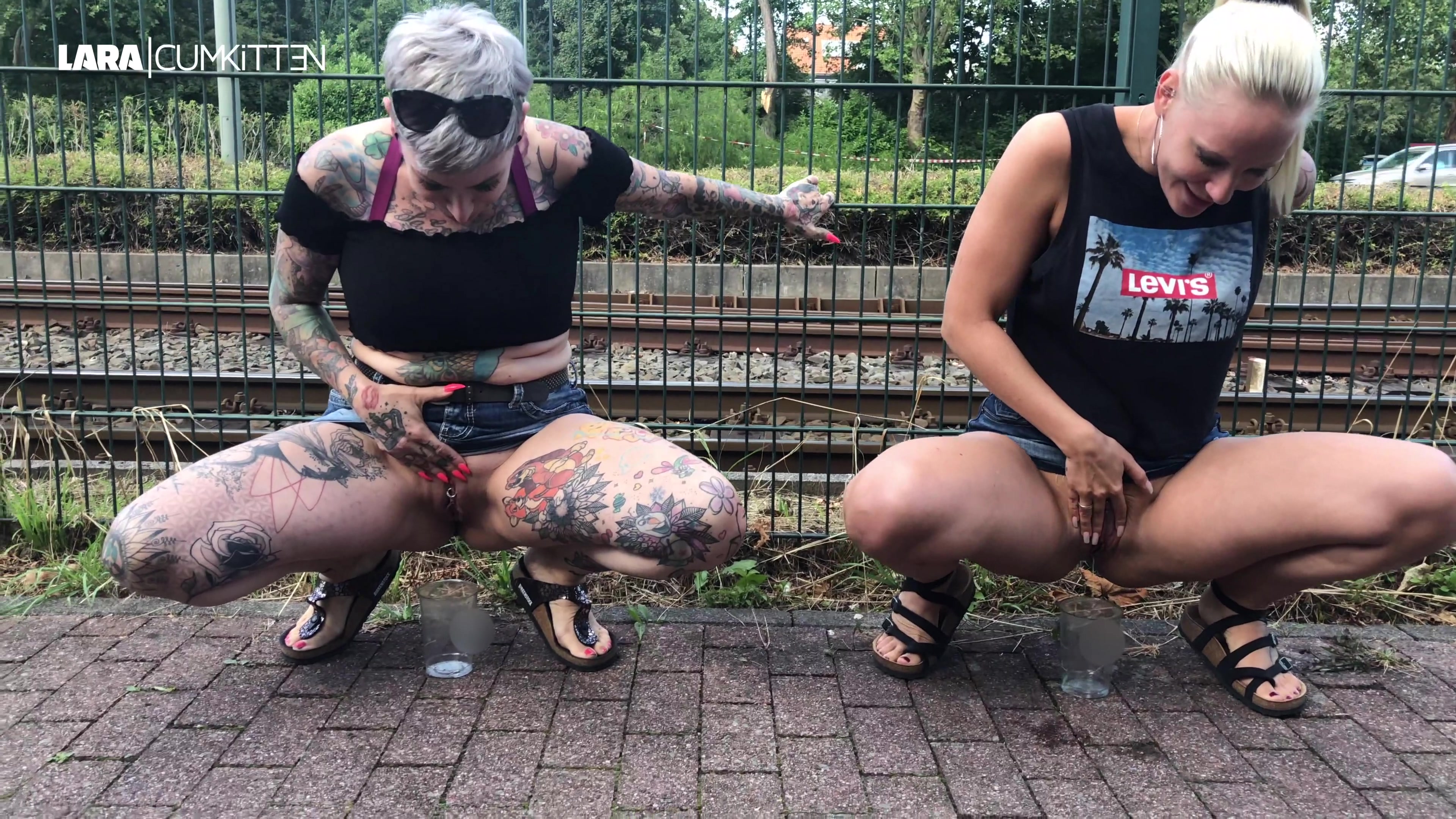 SPANNENDE PUBLIC PISS CHALLENGE - Bei wem sprudelt der Becher über? Meine Freundin CatCoxx und ich schlürfen bereits den 6. Ice-Smoothie an diesem Tag und wir müssen nach der langen Shopping Tour echt mal pissen. Für uns kein Problem, dass wir mitten in der Stadt sind. Im Gegenteil, denn das ist die Gelegenheit um eine geile Piss Challenge zu starten. Wer pisst mehr, bzw. bei wem wird der Becher mit unserem kostbaren Natursekt überlaufen?? Ich will euch hier echt nicht zu viel verraten, denn das würde ja alles aufklären. Es sei nur so viel gesagt: Es ist auf jeden Fall spannend bis zur letzten Sekunde und eine von uns beiden besteht ganz klar auf eine Revanche. BITTE WIE IMMER NICHTS IM VIDEOKOMMENTAR VERRATEN!